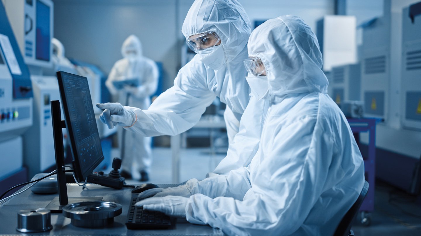 workers in coveralls in a cleanroom